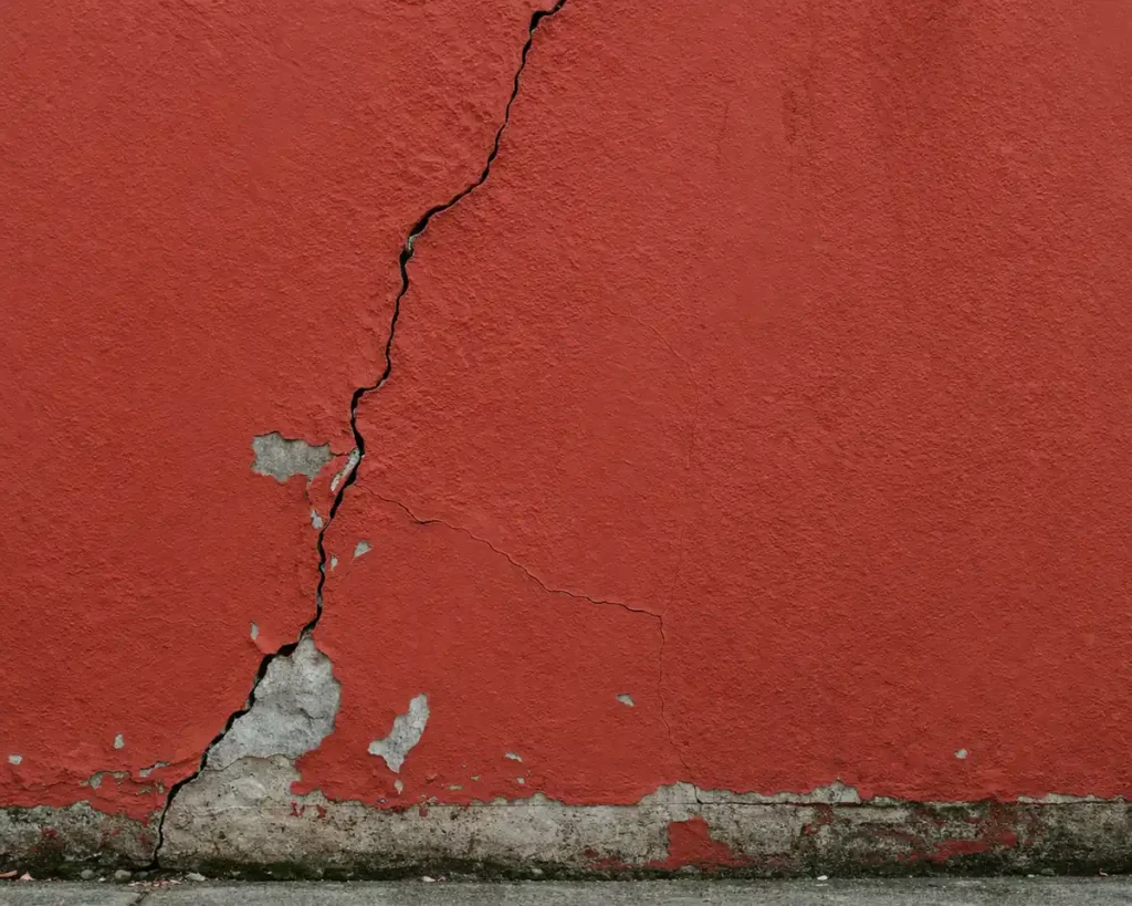 red exterior wall with visible crack before renovation