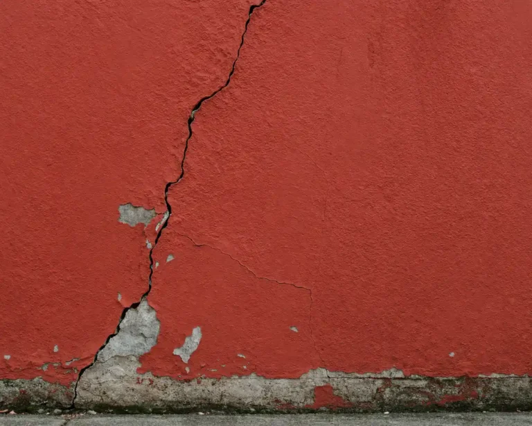 red exterior wall with visible crack before renovation