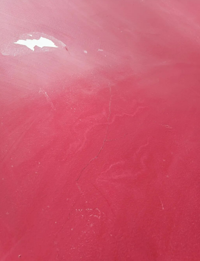 red exterior wall with visible crack before renovation