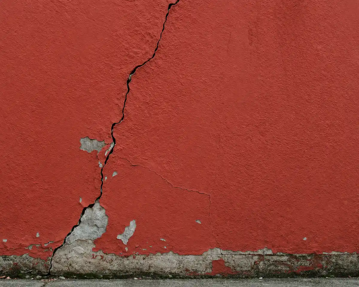 red exterior wall with visible crack before renovation